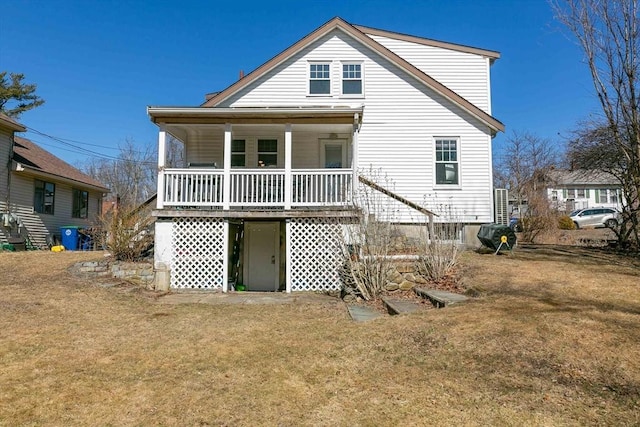 back of property featuring covered porch and a lawn