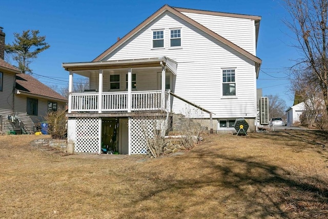 rear view of house with a porch and a yard