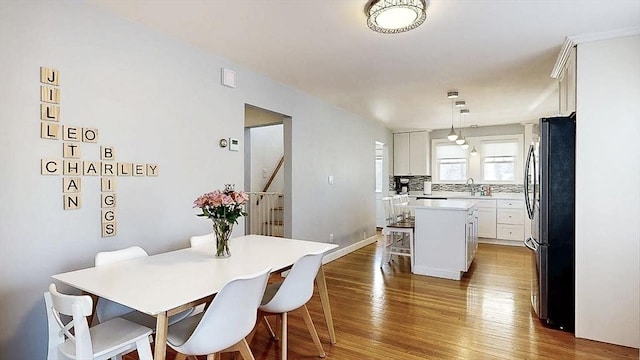 dining area with stairway, baseboards, and wood finished floors