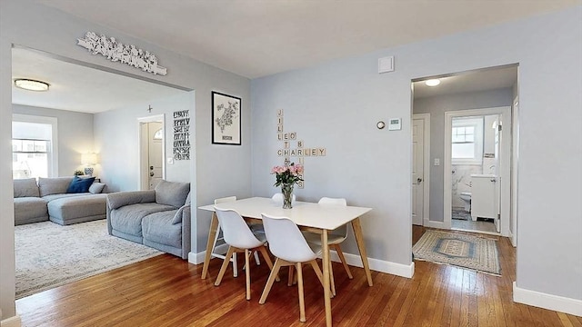 dining space featuring wood-type flooring and baseboards