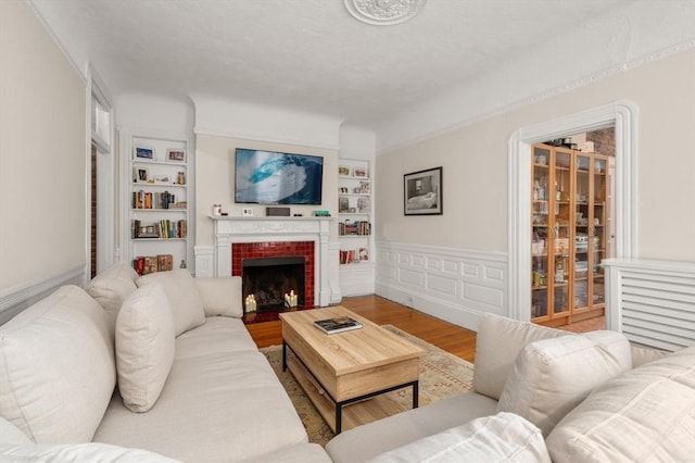 293-295 Commonwealth Ave Unit 3C, Boston, MA 02111 - living room featuring built in features, wood finished floors, and a brick fireplace
