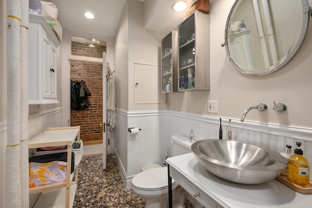 293-295 Commonwealth Ave Unit 3C, Boston, MA 02111 - bathroom with a wainscoted wall, toilet, a shower, brick wall, and vanity