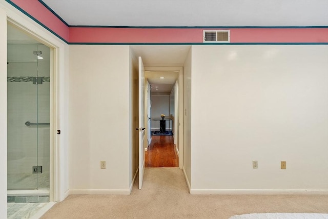 hallway featuring baseboards, visible vents, and carpet