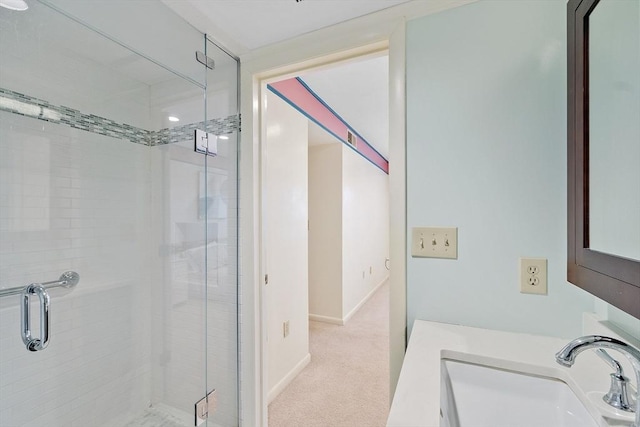 full bath featuring a stall shower, a sink, and baseboards