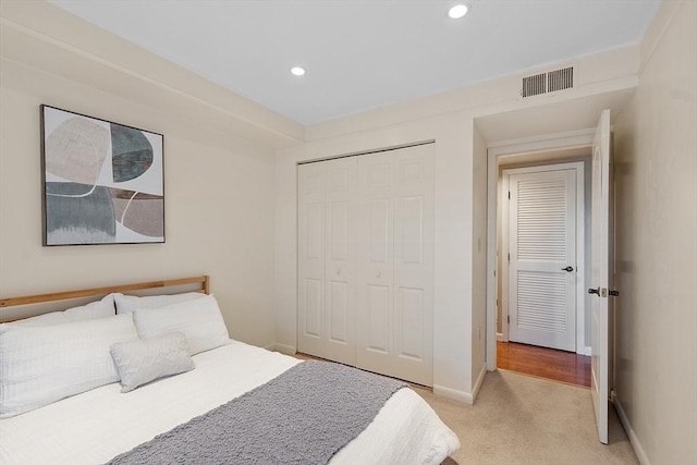 bedroom with light colored carpet, visible vents, a closet, baseboards, and recessed lighting