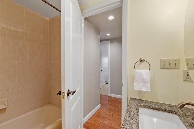 full bath with recessed lighting, a sink, shower / bath combination, baseboards, and wood finished floors