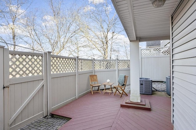 wooden deck featuring fence and cooling unit