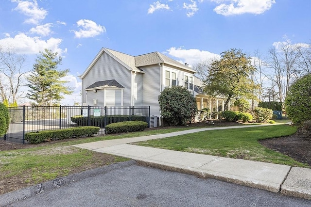 view of home's exterior with fence and a lawn