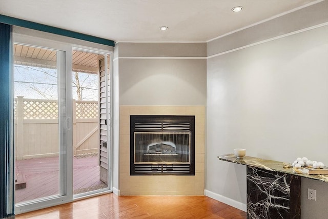 details featuring baseboards, recessed lighting, wood finished floors, and a glass covered fireplace