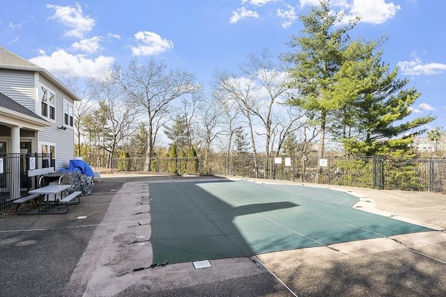 view of sport court featuring fence and a community pool