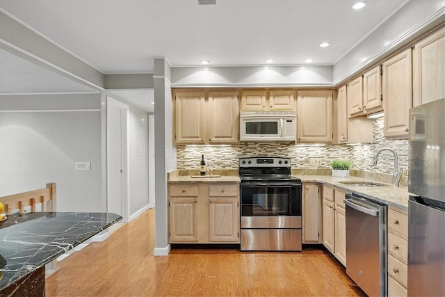 kitchen with light brown cabinetry, a sink, and stainless steel appliances