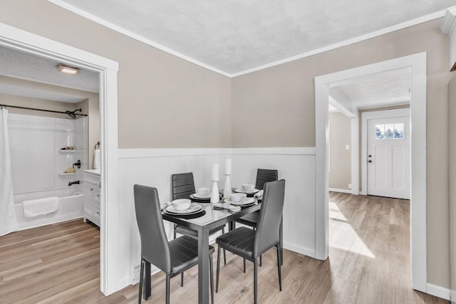 dining area featuring ornamental molding and light wood-type flooring