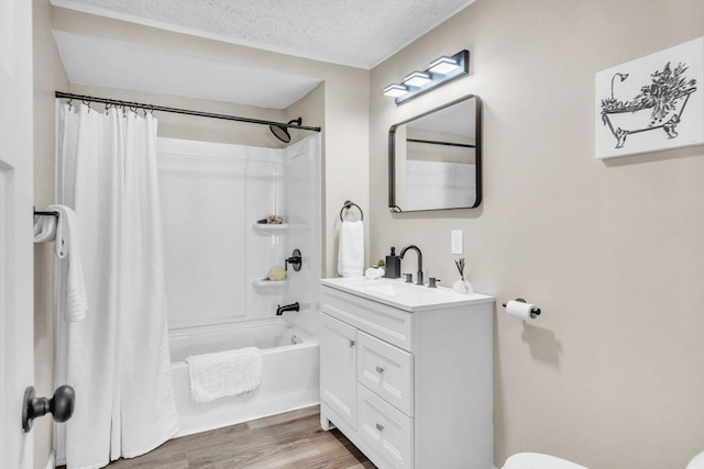 bathroom featuring vanity, hardwood / wood-style floors, a textured ceiling, and shower / bath combo