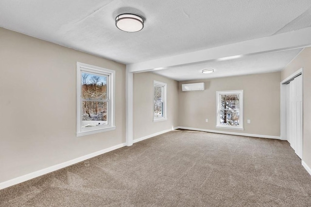 carpeted spare room featuring a wall unit AC