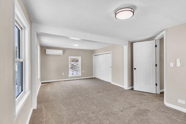 spare room with light colored carpet and an AC wall unit