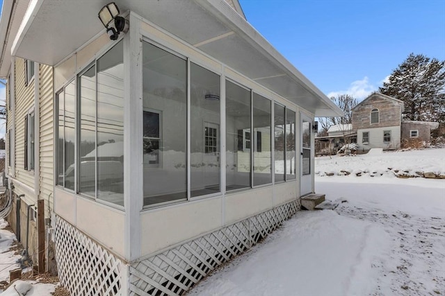 snow covered property featuring a sunroom