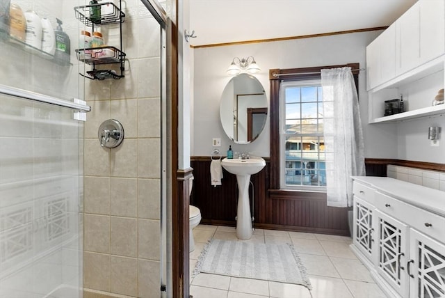 full bathroom with tile patterned floors, a wainscoted wall, a shower stall, and toilet