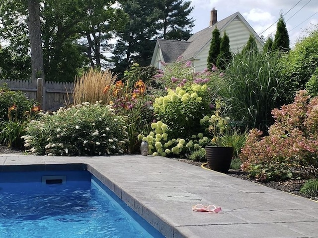 view of swimming pool with a swimming pool and fence