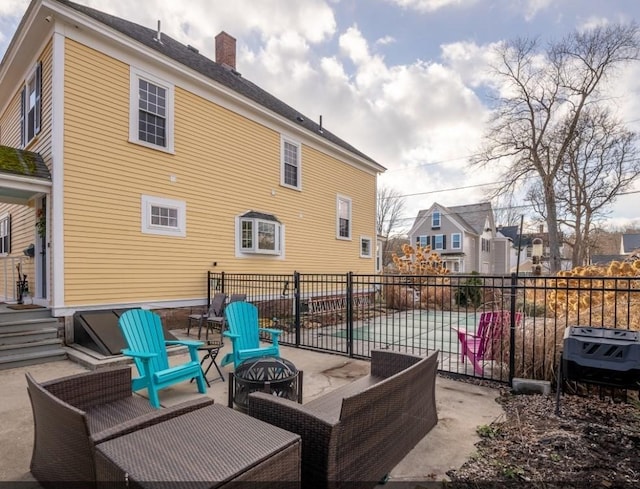 rear view of house with fence, an outdoor fire pit, and a patio area