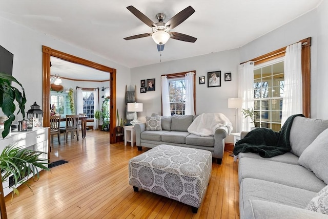 living room featuring a wealth of natural light, visible vents, light wood-type flooring, and ceiling fan