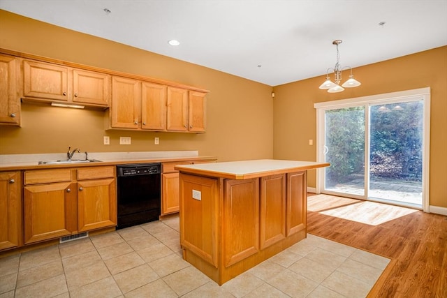 kitchen featuring visible vents, a center island, dishwasher, a sink, and light countertops