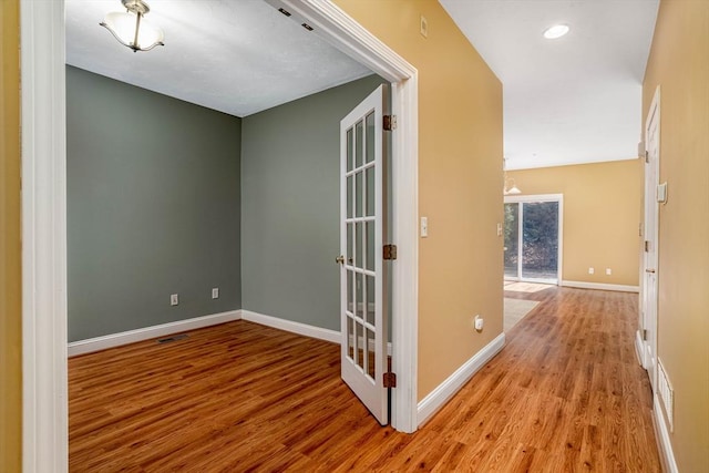 unfurnished room with visible vents, baseboards, recessed lighting, and wood finished floors