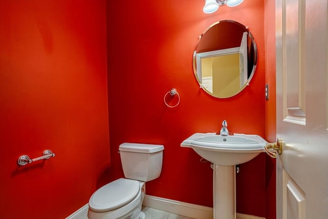 bathroom with toilet, tile patterned floors, and baseboards