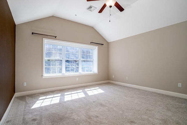 empty room featuring visible vents, baseboards, ceiling fan, carpet flooring, and lofted ceiling