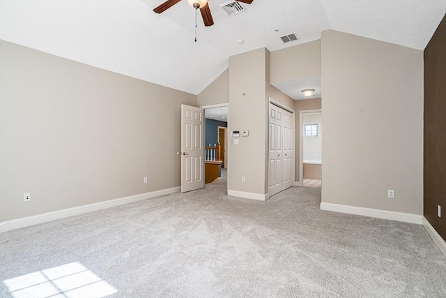 unfurnished bedroom with baseboards, visible vents, light colored carpet, and vaulted ceiling