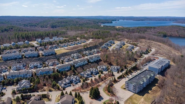 drone / aerial view featuring a water view, a residential view, and a view of trees