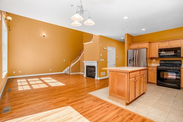 kitchen featuring visible vents, light countertops, black appliances, and light wood-style floors