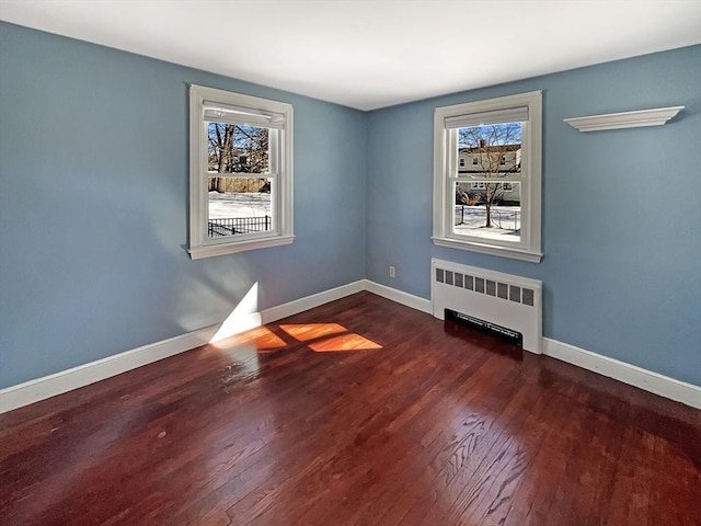 unfurnished room featuring baseboards, a healthy amount of sunlight, and radiator