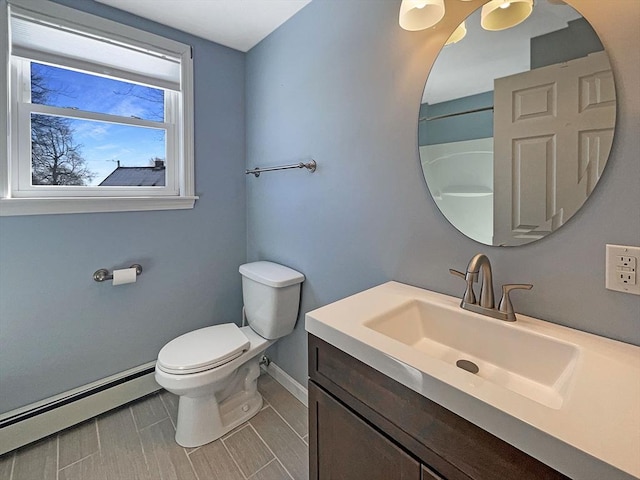 bathroom featuring a baseboard heating unit, baseboards, vanity, and toilet