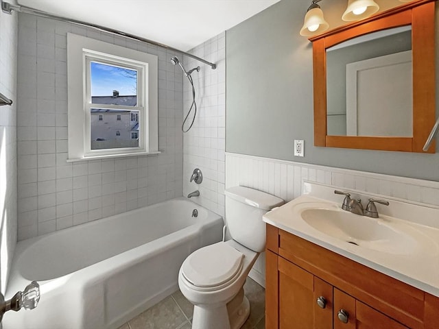 bathroom featuring shower / bathing tub combination, toilet, wainscoting, vanity, and tile patterned floors