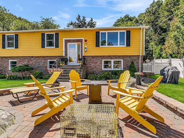 188 Atlantic St, Gloucester, MA 01930 - view of front of house featuring an outdoor fire pit, a patio area, and brick siding
