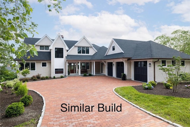 46 Buttonwood Ln Unit 46, Ipswich, MA 01938 - view of front of house with a garage, decorative driveway, roof with shingles, and a porch