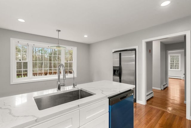 kitchen with a sink, a baseboard heating unit, dishwasher, and white cabinets