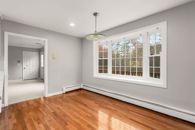 unfurnished dining area featuring recessed lighting, baseboards, a baseboard radiator, and light wood finished floors