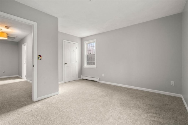 carpeted empty room featuring baseboards and a baseboard radiator