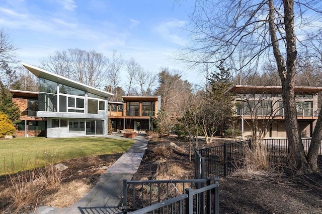 exterior space with a front yard, a sunroom, and fence