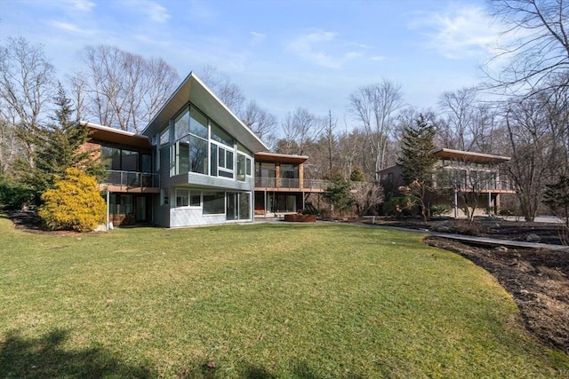 rear view of property featuring a deck and a lawn