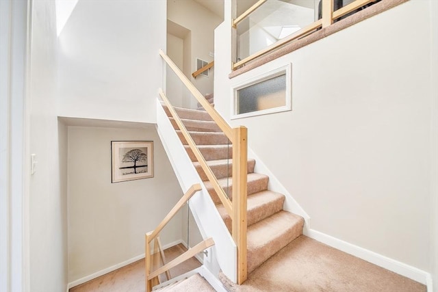 222 Algonquin Unit 222, Ashland, MA 01721 - staircase featuring carpet floors, baseboards, and a towering ceiling