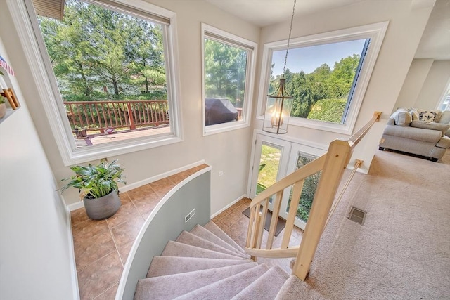 222 Algonquin Unit 222, Ashland, MA 01721 - stairway featuring a chandelier, healthy amount of natural light, baseboards, and tile patterned floors