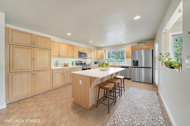 222 Algonquin Unit 222, Ashland, MA 01721 - kitchen featuring appliances with stainless steel finishes, light brown cabinetry, a sink, a kitchen island, and light countertops