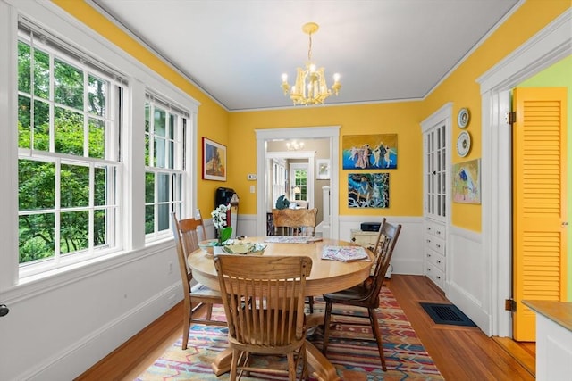21 Marsh St, Dedham, MA 02026 - dining space with wood finished floors, a chandelier, a wainscoted wall, and crown molding