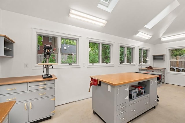 21 Marsh St, Dedham, MA 02026 - kitchen featuring gray cabinets, finished concrete flooring, open shelves, a skylight, and a kitchen island