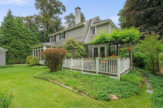 21 Marsh St, Dedham, MA 02026 - rear view of property with a lawn, a chimney, a sunroom, a pergola, and a wooden deck