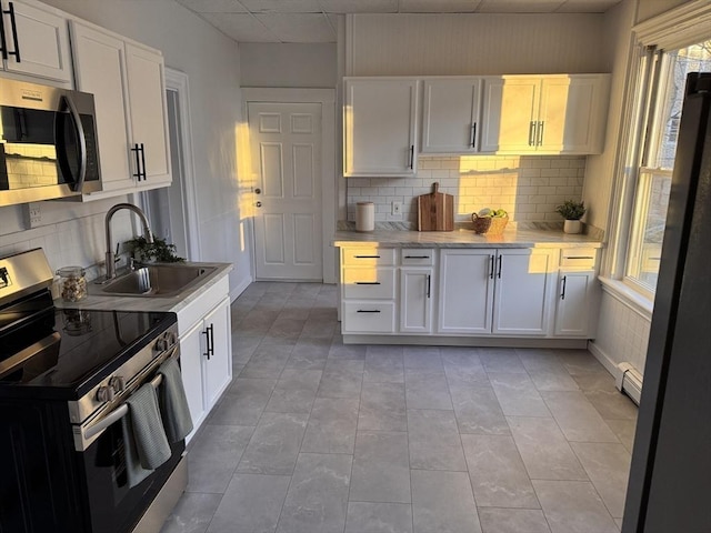 kitchen featuring stainless steel appliances, white cabinetry, and sink