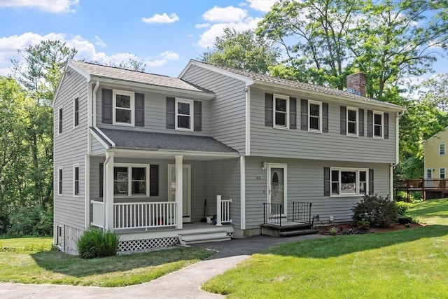 65 Martin Rd, Tewksbury, MA 01876 - view of front of property with a chimney, a front lawn, a porch, and roof with shingles