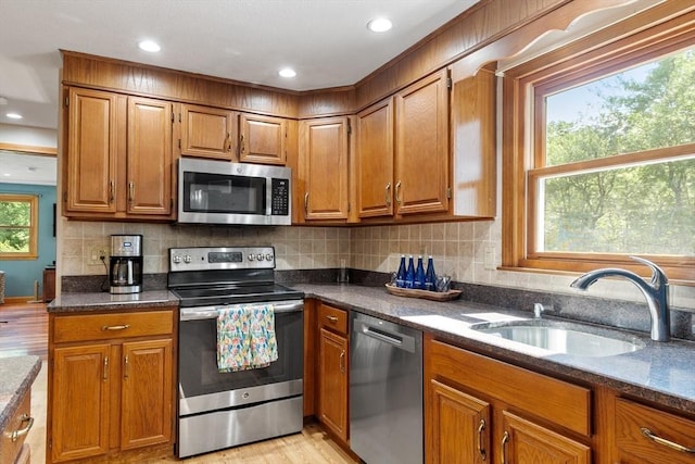 65 Martin Rd, Tewksbury, MA 01876 - kitchen with stainless steel appliances, brown cabinets, light wood-style flooring, tasteful backsplash, and recessed lighting